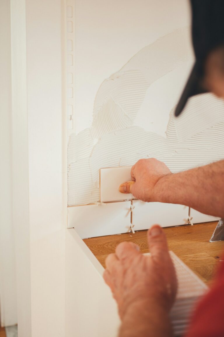 Hands pressing and smoothing a freshly drywalled white wall