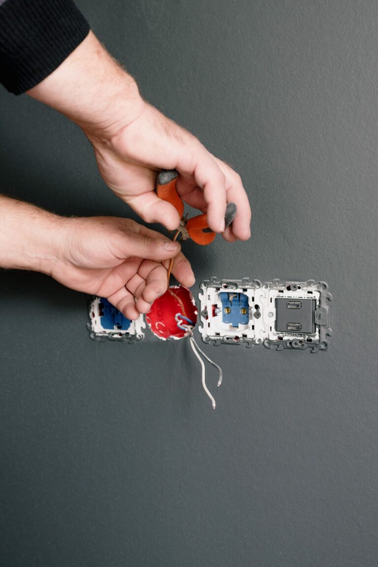 Electrician installing an outlet with pliers